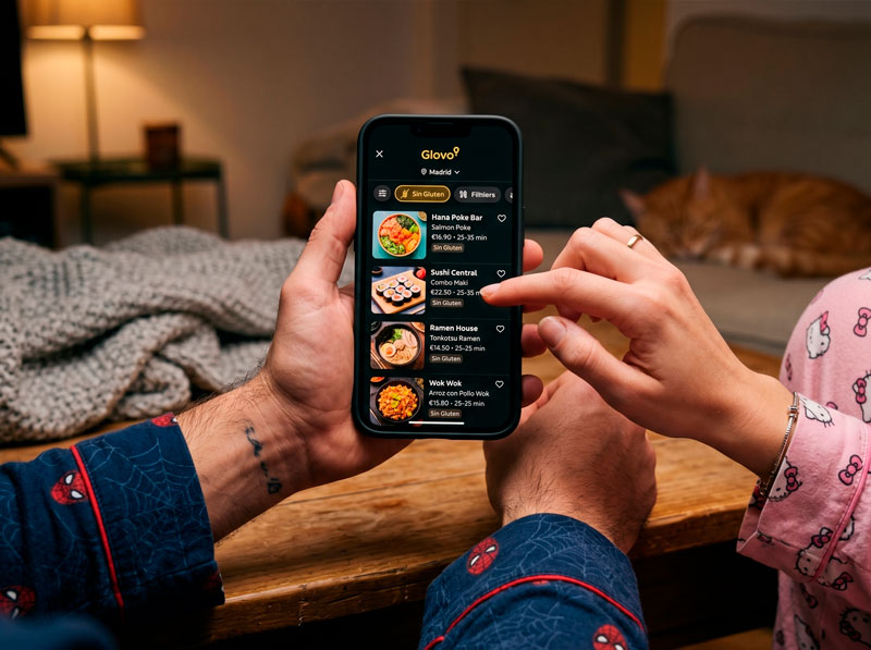 Pareja evaluando opciones delivery sin gluten en Glovo con el teléfono móvil